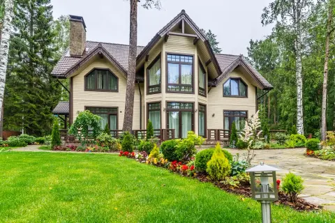 Elegantes casas canadienses rodeadas de exuberante vegetación y un jardín cuidado.