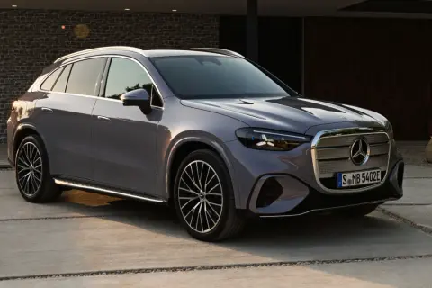 Un elegante GLC eléctrico 2026 gris metálico, con diseño moderno y llantas deportivas, estacionado en una entrada de concreto.