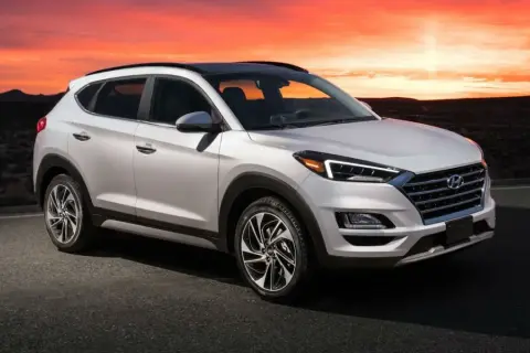 Un Hyundai Tucson blanco con un motor potente, listo para la aventura al atardecer en un paisaje desértico.