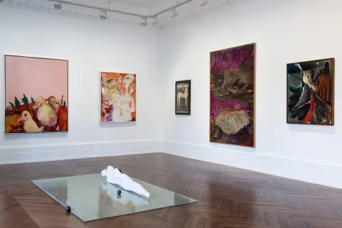 Artistic display at Michael Werner Gallery featuring abstract paintings and a sculpture on a mirrored surface.