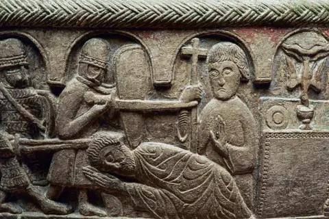 Stenrelief med en scen som påminner om martyriet av **Saint Sebastian**. Soldater förbereder sig, en man ligger ner, och en annan håller ett kors.