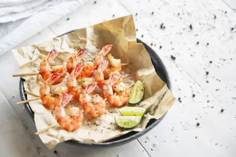 Spiedini di gamberetti succulenti, pronti per essere gustati. Scopri come cuocere i gamberetti surgelati per un piatto perfetto.