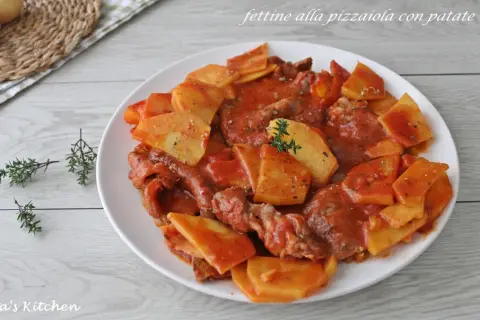 Piatto di fettine di carne in salsa pizzaiola con patate a fette, guarnito con timo fresco.