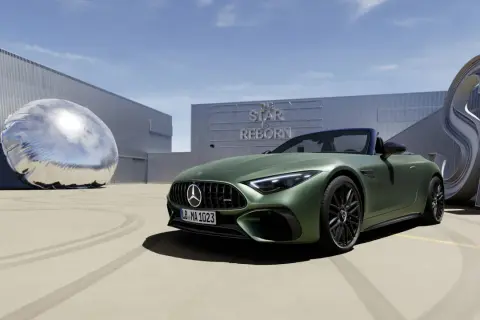 Zielony Mercedes SL 63 AMG na tle budynku z napisem "The Star is Reborn" i futurystyczną rzeźbą.