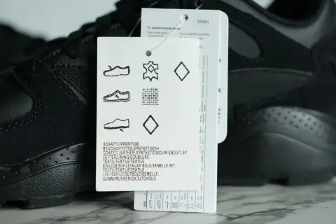 Czarny but sportowy z metką, na której widnieje symbol skóry naturalnej, wskazujący na wysoką jakość materiału.