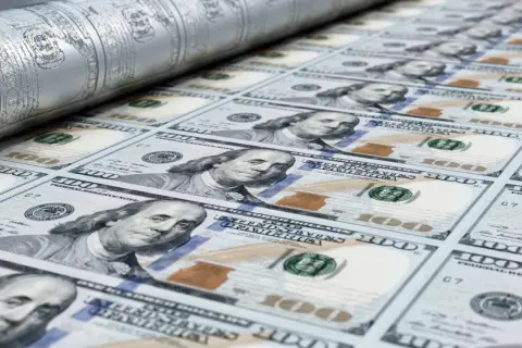 Druk banknotów 100 dolarowych na maszynie drukarskiej.