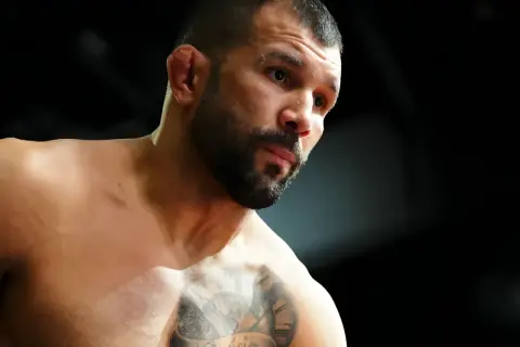 Rodolfo Vieira, en MMA-fighter med intensiv blick och tatueringar på bröstet, förbereder sig för strid.