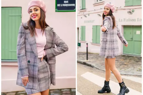 Dziewczyna w różowym beretce i kraciastej marynarce w stylu preppy, z mini spódniczką i botkami, pozuje na tle paryskiej uliczki.