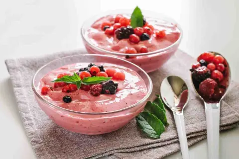 Spumone alle fragole Bimby, fresco e cremoso, guarnito con frutti di bosco e menta. Perfetto per un dessert leggero.