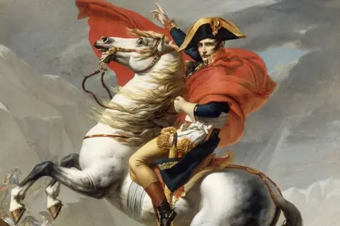 Napoléon, sur son cheval blanc, brandit son épée, symbole de sa victoire. Le vent agite sa cape rouge.