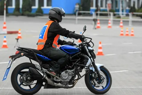Motocyklista na placu manewrowym, przygotowuje się do egzaminu. Sprawdza, jaka jest prawo jazdy a2 cena, by móc legalnie jeździć.