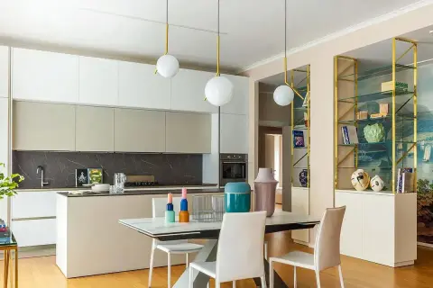 Cucina moderna con isola e zona pranzo. Parete con libreria dorata e affresco marino, un'ispirazione per idee pareti soggiorno moderne.