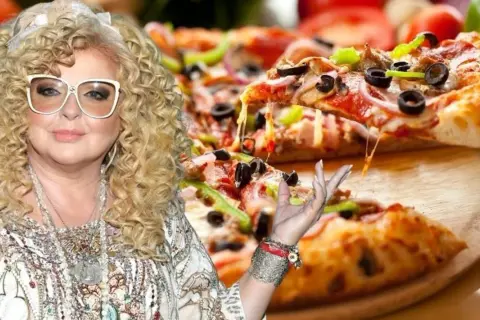Magda Gessler z pizzą, ser ciągnie się z kawałka.