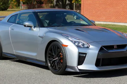 Srebrny Nissan GTR z pomarańczowymi zaciskami hamulcowymi, gotowy do jazdy.
