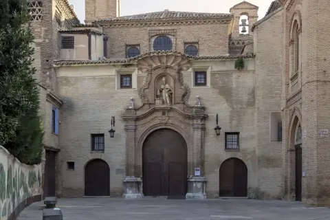 Fachada de la iglesia de las canonesas del Santo Sepulcro, con su gran portalón de madera y una escultura en el nicho central.