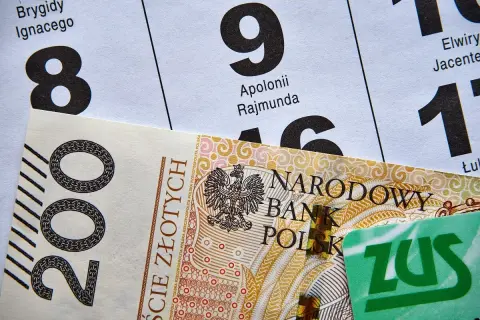 200 zł i zielona karta ZUS na tle kalendarza. Czekasz na przelew, kiedy ZUS robi przelewy?