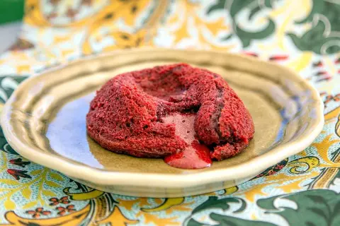 En rykande red velvet-fondant med smältande kärna på en tallrik.