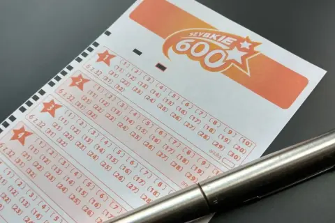 Długopis leży na kuponie lotto "Szybkie 600", gotowy do zaznaczenia liczb. Dowiedz się, jak sprawdzić numery lotto i czy masz szansę na wygraną!