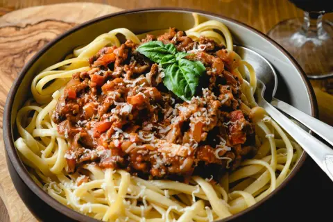 Ein Teller Spaghetti mit herzhafter Bolognese-Sauce, garniert mit Basilikum und Parmesan. Perfekt für ein klassisches bolognese rezept.