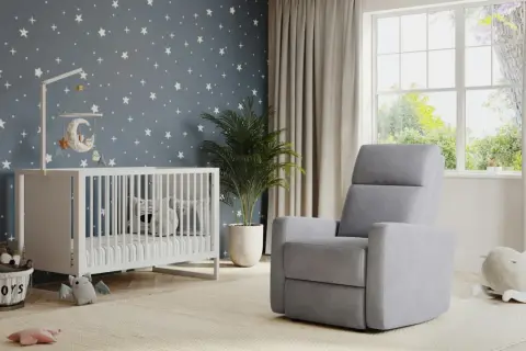 A modern nursery idea with a starry wallpaper, white crib, plush toys, and a comfy grey recliner.