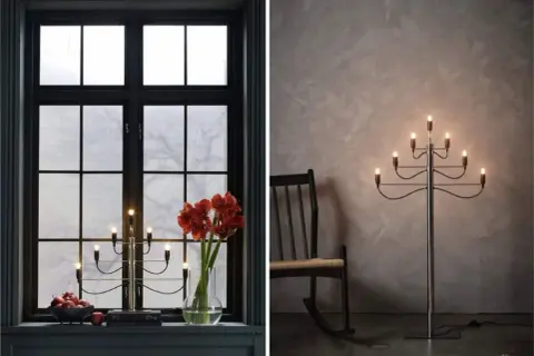 Två adventsljusstake inspirationer: en i ett mörkt fönster med amaryllis och äpplen, en annan som golvlampa bredvid en gungstol.