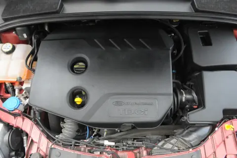Silnik Duratorq TDCI w Fordzie Focus MK3 1.6. Widoczna czarna osłona silnika z logo.