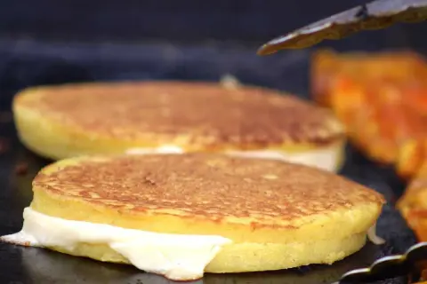 Arepas de choclo doradas y rellenas de queso derretido, listas para ser disfrutadas.