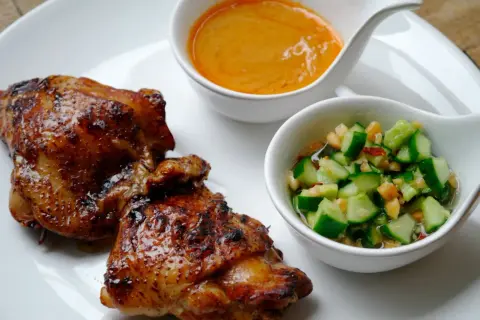 Krispigt, glansigt sticky chicken serveras med en krämig sås och en fräsch gurksallad.