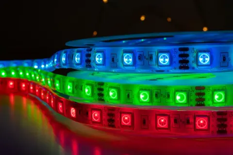 Taśmy LED RGB i ARGB w kolorach czerwonym, zielonym i niebieskim, tworzące świetlistą tęczę.
