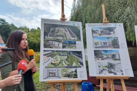 Kobieta z mikrofonami prezentuje projekty architektoniczne schroniska dla zwierząt w Zielonej Górze.