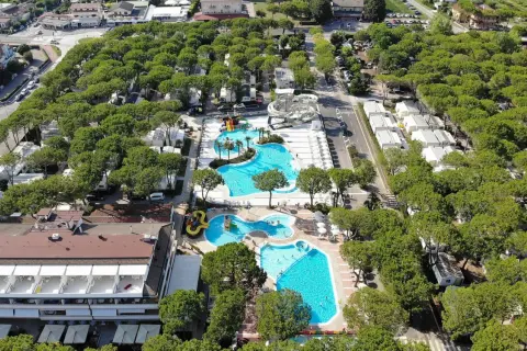 Malowniczy camping residence village z basenami, zjeżdżalniami i domkami wśród drzew. Idealne miejsce na wakacje.