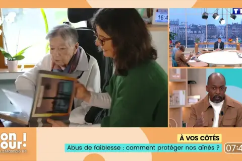 Une femme montre un album à une personne âgée, évoquant l'abus de faiblesse sur personne âgée et comment protéger nos aînés.