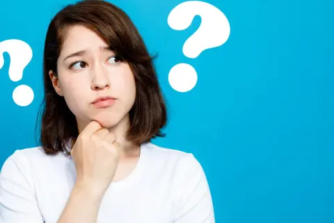 Junge Frau mit nachdenklichem Blick, die sich am Kinn kratzt. Mehrere Fragezeichen deuten auf ihre fünf head move-Gedanken hin.
