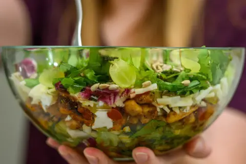 Sałatka gyros z kurczakiem i kapustą pekińską, pełna świeżych warzyw, sera i słonecznika, w szklanej misce.