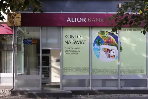 Alior Bank zaprasza na konto jakże osobiste z kartą dopasowaną do podróży. Reklama z jaszczurką i palmami.