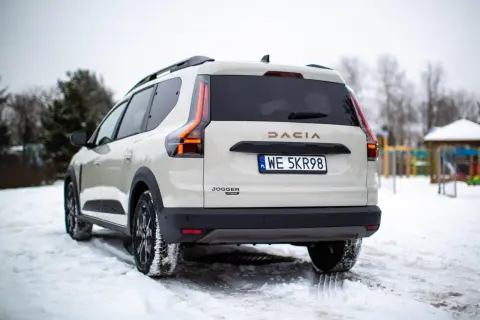 Biała Dacia Jogger Hybrid na śniegu. Sprawdź atrakcyjną dacia jogger cena i wybierz swój wymarzony samochód.