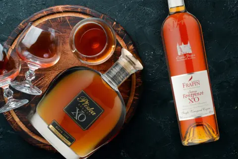 Dwie butelki i kieliszki z brandy, w tym Pliska XO i Frapin Château Fontpinot XO. Dobre brandy do 100 zł.