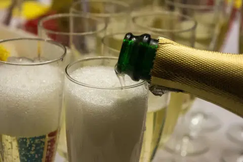 Schaumiger Prosecco wird in Gläser gegossen. Aber kann Prosecco schlecht werden? Ja, wenn er falsch gelagert wird.