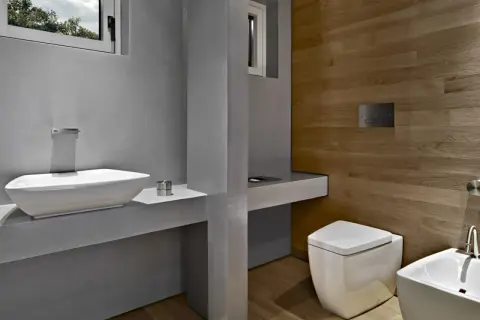Bagno moderno con lavabo bianco, WC squadrato e pannello di scarico traslato. Problemi di design?