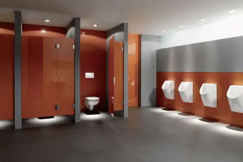 Moderne schul toilette mit orangen Kabinen und Reihen von Urinalen.