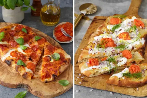 Två pizzor på träskärbrädor. En med pepperoni och basilika, den andra med gräddfil, rödlök, dill och rom. Båda ser ut att ha en härlig pizza sås.