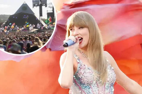 Taylor Swift singing on stage at Glastonbury festival with a large crowd and pyramid stage in the background.