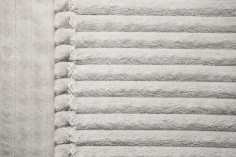 Miękki, prążkowany materiał mikrofibra w jasnym kolorze.