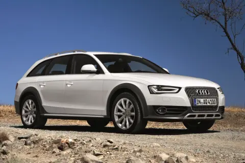 Białe Audi A4 B8 Allroad quattro na kamienistej drodze pod błękitnym niebem.