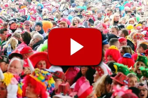 Bunte Kostüme und fröhliche Gesichter bei einem Karnevalsumzug. Hier gibt es die besten Karneval Lieder zum Mitsingen!