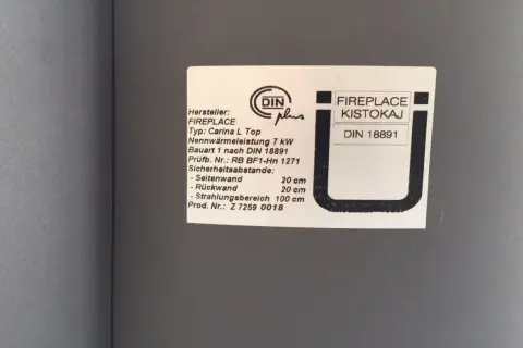 Typenschild eines FIREPLACE Kaminofens, Modell Carina L Top, mit DIN 18891 Zertifizierung und Sicherheitsabständen.