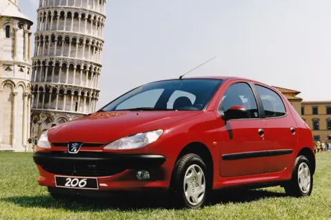 Czerwony Peugeot 206 na tle Krzywej Wieży w Pizie.