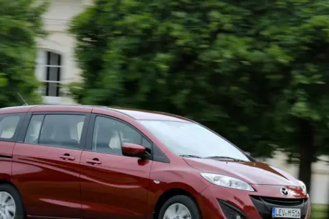 Czerwona Mazda 5 w ruchu, zgrabna i przestronna, idealna na rodzinne wycieczki. Poznaj jej mazda 5 wymiary.