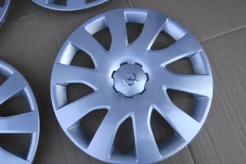 Srebrne kołpaki Opel Vivaro z logo marki. Komplet czterech sztuk, idealny do odświeżenia wyglądu Twojego auta.