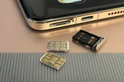 Dwie karty SIM i tacka na karty obok telefonu. Czy można mieć dwie karty SIM z tym samym numerem? To pytanie nurtuje wielu użytkowników.